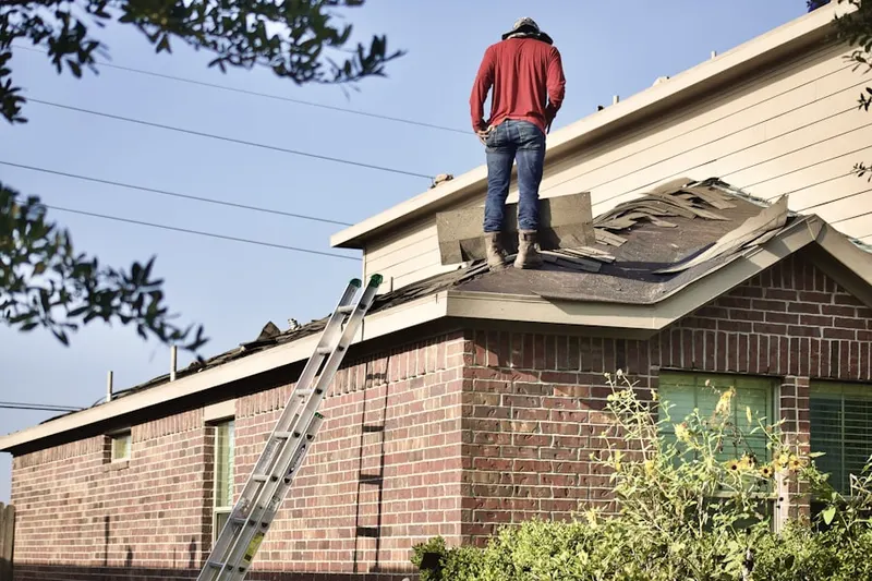 Professional roofer working on a residential roof in East Windsor Hill